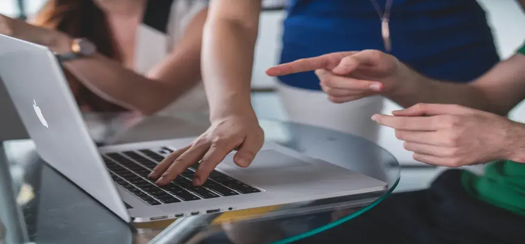 Close-up of hands using laptop in office environment