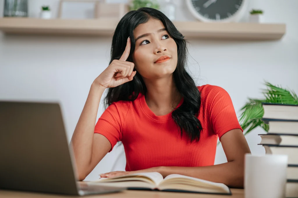 Young Woman working with laptop desk thinking about solving problems